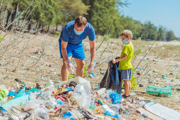 Volunteers in blue face mask. Father, son pick up garbage which pollute beach near lazur sea....