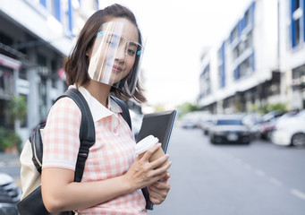 Young student Asian woman wearing mask face shield to prevent infection corona virus at outdoor street