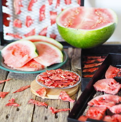 The process of drying a watermelon. On a wooden table are laid out a natural watermelon, grates...