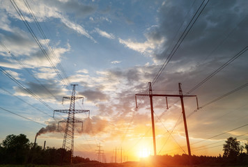 High-voltage power lines at sunset or sunrise. High voltage electric transmission tower