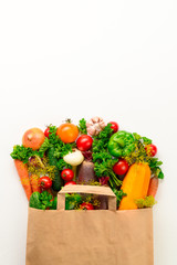Paper bag of different vegetables on a white background. Top view, copy space. Bag food concept.