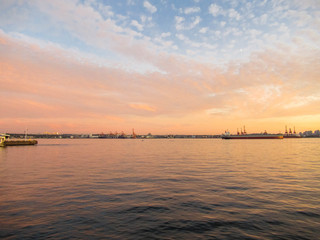 Cargo ships in Vancouver at sunset with red and yellow tones.