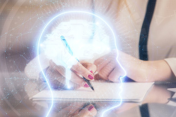 Multi exposure of woman's writing hand on background with brain hud. Concept of learning.