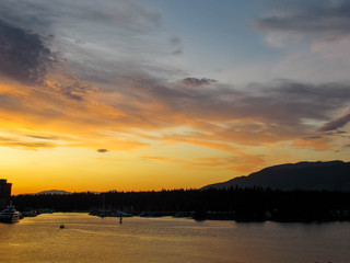 Obraz premium Beautiful yellow sunset over Stanley Park in Vancouver in September.