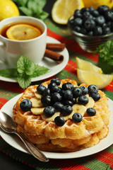 Belgian waffles with blueberry and a cup of tea with lemon