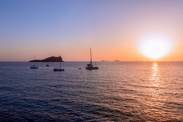 Naklejka na ściany i meble Beautiful sunset on the island of Ibiza. View from the most beautiful beaches on the island Cala Escondida. Balearic Islands. Spain