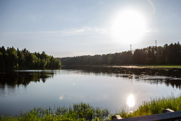 The sun is reflected in a forest lake