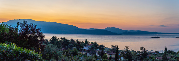 Sunrise in Manerba del Garda with the silhouettes of the mountains in the background on Lake Garda,...