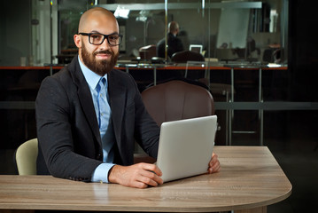 Businessman in a blue shirt. Man in a jacket with a laptop in glasses. Bearded office worker.