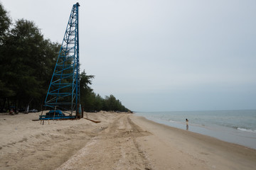 A crane is accepting piles on the beach.