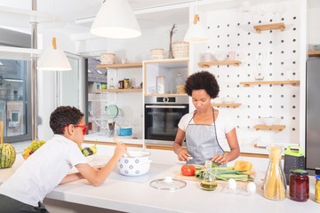 Mother and son cooking food together at home