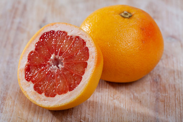 Sliced fresh juicy pink pomelo on wooden table. Concept of health benefits of citrus fruits