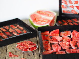 Autumn harvesting season. The process of preparing sweet treats for future use, from a whole green watermelon to dried pieces of homemade dried watermelon fruit on a plate.