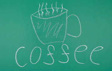 On a green Board, a Cup of coffee is drawn in chalk and the word Coffee is written, top view.