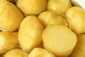 Naklejka na ściany i meble Beautiful, yellow potatoes cooking in a pot close-up