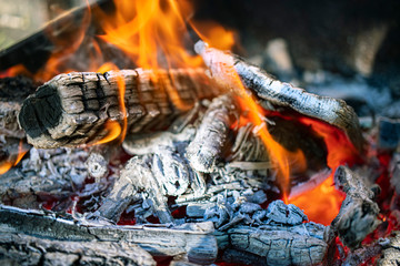 Burning firewood and coals in the grill. Close-up. Macro shooting. Burning fire. Grilling meat. The energy of fire