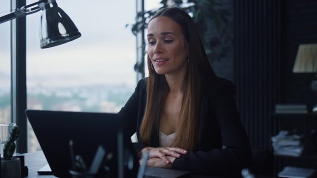Businesswoman video chatting on laptop in office. Lady talking with client