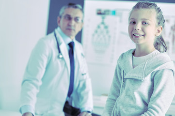 Obraz premium Portrait of a cute little girl and her doctor at hospital