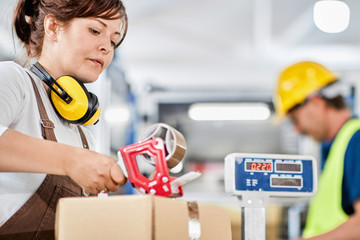 Woman working in a factory, packaging process in warehouse