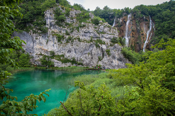 A large waterfall flowing over a mountain into a lake at Plitvice Lakes, Croatia