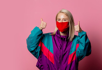 Woman in face mask and 80s clothes on pink background