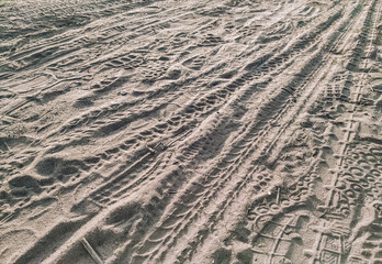 The texture of the wheel tracks of cars and bicycles on a dirt road from the sand.