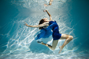  Woman in blue dress under water.