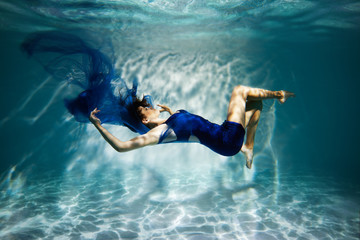  Woman in blue dress under water.