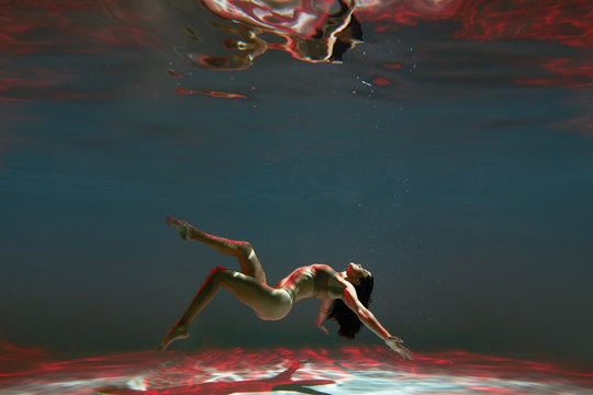 A woman with nice body dancing under water.Underwater photo