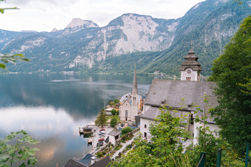 Fototapeta na wymiar Austria, Hallstatt UNESCO historical village. Scenic picture-postcard view of famous mountain village in Austrian Alps in Salzkammergut area at beautiful light in summer. Views over roofs of the lake.