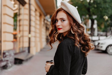 Romantic ginger woman in french beret looking back. Outdoor photo of adorable brunette girl...