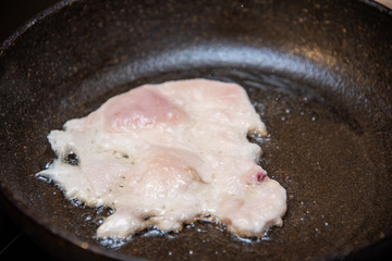 Chicken fillet fried in oil in a pan