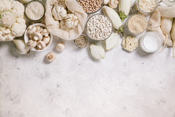 White vegetables and mushrooms, rice, quinoa, legumes, white peppercorns, coconut oil on a white background. Healthy eating and the concept of clean eating.