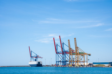 Obraz premium Gantry cranes background with copy space. Seascape of dock with container cranes on a blue sky.