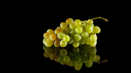 Bunch of white grapes isolated on a black glossy background with realistic reflection