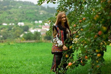 girl in embroidery under an apple tree