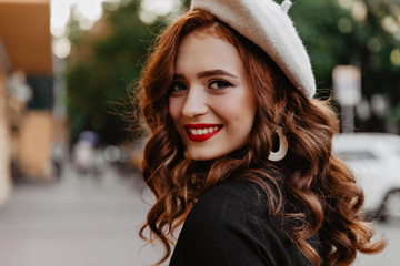 Inspired french model laughing on the street. Ginger girl in trendy beret walking outdoor in autumn...