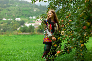girl in embroidery under an apple tree