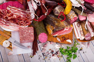 Variety of meats, sausages and mince with herbs on table