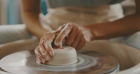Young woman making pottery in the studio, handmade ceramics, close up detail of hands and clay