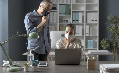 Business people working together in the office and wearing face masks