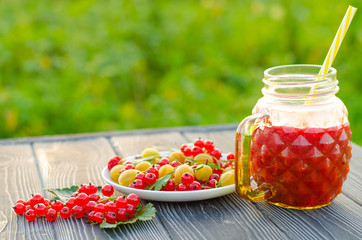 Fresh berry smoothie with red currant and yellow gooseberry on a wooden rustic table. Healthy eating, Summer food, Detox or Diet concept.
