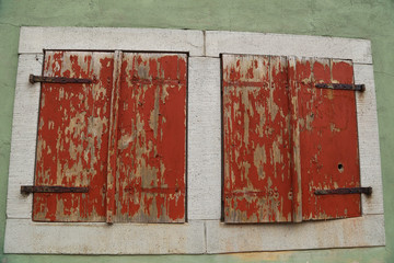 Windows with closed shutters in the old house