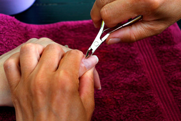 Manicurist working with clients nails at table, close up. Healthy, well groomed nails, natural beauty. Selective focus.