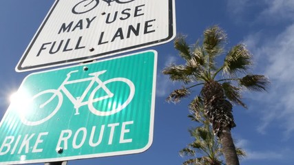 Bike Route green road sign in California, USA. Bicycle lane singpost. Bikeway in Oceanside pacific tourist resort. Cycleway signboard and palm. Healthy lifestyle, recreation and safety cycling symbol.