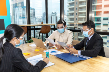 Business in new normal. Office workers wearing face mask and protection while having internal meeting for new business strategy or plan. Technology for new normal
