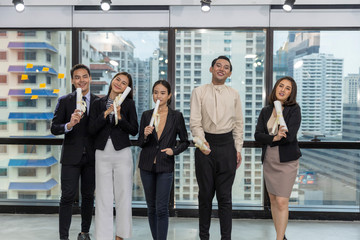 Fototapeta premium Business office workers celebrate a great acheivement together after major effort. Award of great success by working together in a business office. Moment of appreciation with team sprite