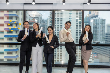 Obraz premium Business office workers celebrate a great acheivement together after major effort. Award of great success by working together in a business office. Moment of appreciation with team sprite