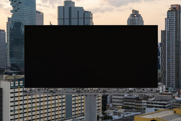 Obraz premium Blank black road billboard with Bangkok cityscape background at sunset. Street advertising poster, mock up, 3D rendering. Front view. The concept of marketing communication to promote or sell idea.