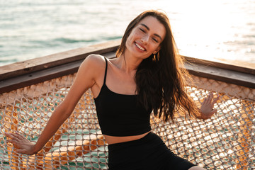 Image of young happy girl laughing while sitting in hammock